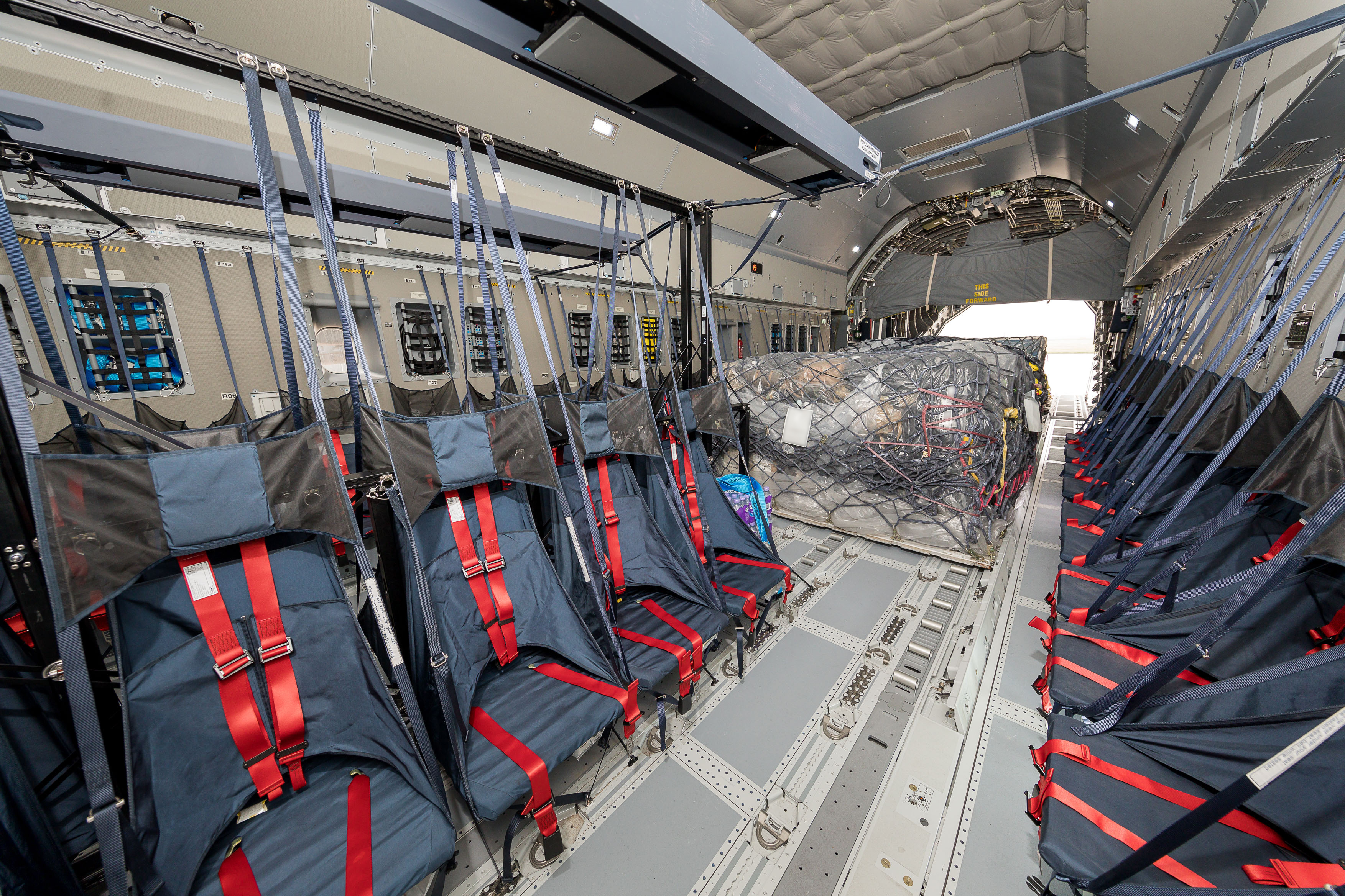 Photo: Image shows the Atlas cargo bay, with two rows of seats centre fwd, and one row on each sidewall. Aditionally, there are loaded cargo pallets centre aft.